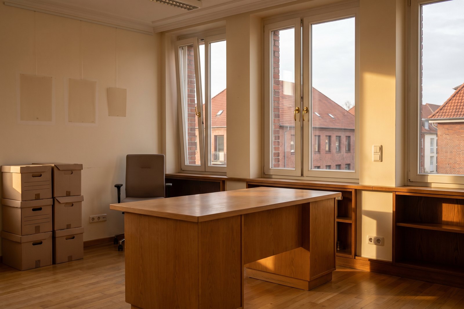 Ein leer geräumtes Büro mit Archivkartons und hellen Flecken an der Wand